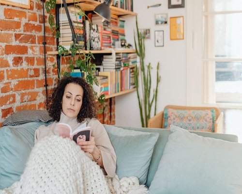 person reading a book in a comfortable room
